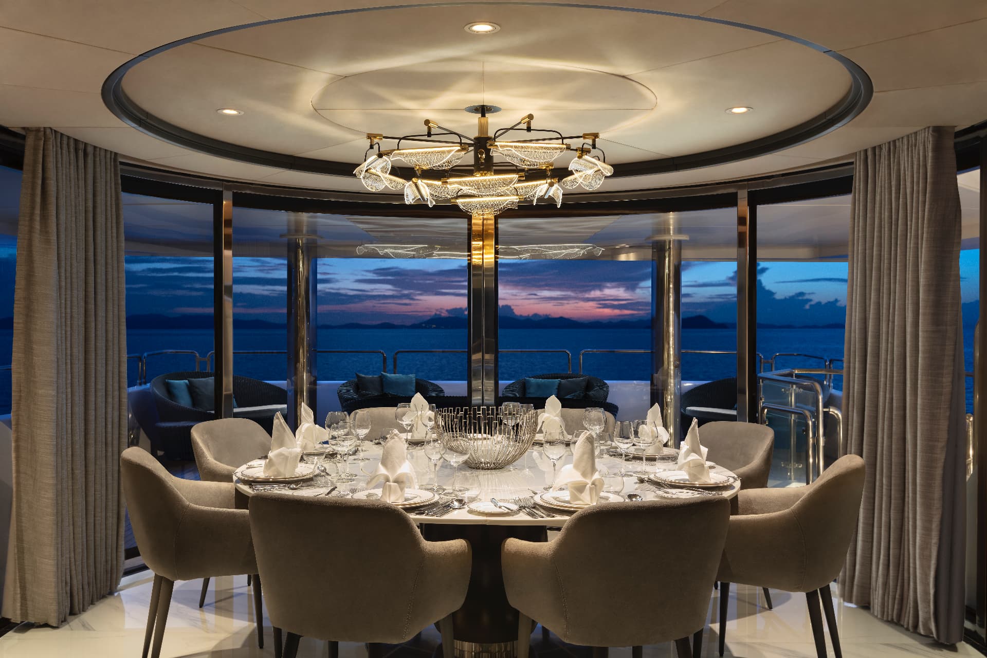 Phuket superyacht charter sky lounge dining table laid for dinner at dusk